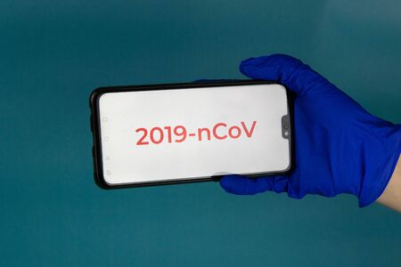 Coronavirus 2019-nCoV. Corona virus outbreaking. Epidemic virus Respiratory Syndrome. Hand holds a phone with an open tab coronavirus 2019 nCoVの写真素材