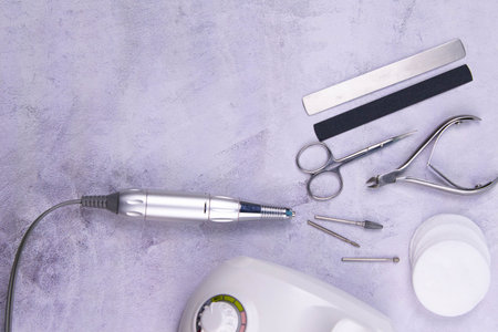 Set of cosmetic tools for manicure and pedicure on a concrete background. Gel polishes, milling...