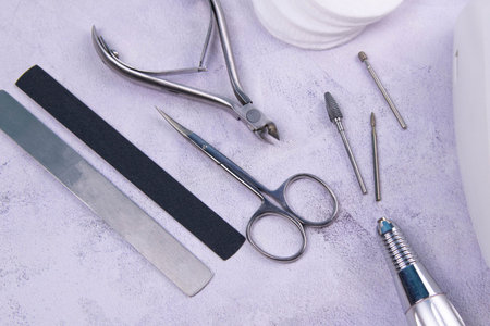 Set of cosmetic tools for manicure and pedicure on a concrete background. Gel polishes, milling...