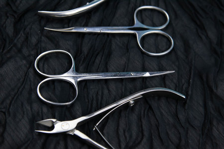 A set of cosmetic tools for manicure and pedicure stand on a black background. scissors and tongs....