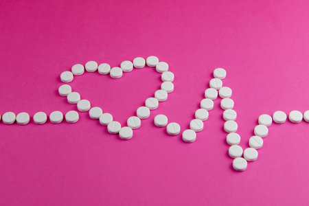 Medicine, healthcare and pharmacy concept - pills and of drugs in shape of the heart and heart rhythms.の写真素材