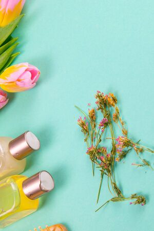 Spa treatments on the green table are a sprout, three white towels, oils, avocados and tulips. Spring concept of a healthy body.の写真素材