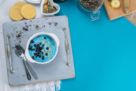 Cottage cheese with jam, fresh blueberries and pumpkin seeds in a ceramic bowl, closeup.の写真素材