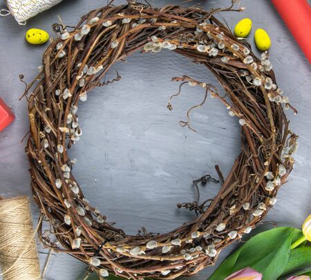 Easter wreath, yellow Easter eggs around tulips, gifts and wrapping paper. Top views with clear spaceの写真素材