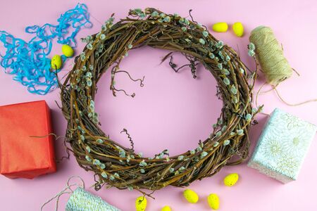 Easter willow wreath and blue Easter eggs on blue background. Top view, copy space.の写真素材