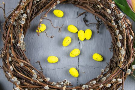 Easter willow wreath and blue Easter eggs on blue background. Top view, copy space.の写真素材