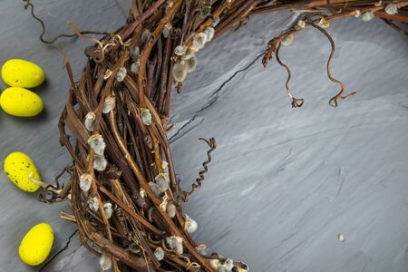 Easter willow wreath and blue Easter eggs on blue background. Top view, copy space.の写真素材