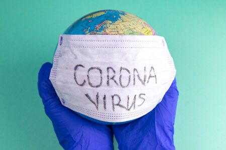 World Corona virus attack concept. world earth put mask to fight against Corona virus. Concept of fight against virus, danger and public health risk disease.の写真素材