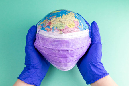 World Corona virus attack concept. world earth put mask to fight against Corona virus. Concept of...