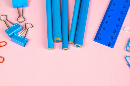 Multi-colored blue pencils rulers, pens, pencils and scissors and stationery stand on a pink background/の写真素材