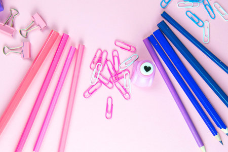Multi-colored blue and pinc pencils rulers, pens, pencils and scissors and stationery stand on a...