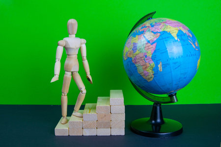 Wooden man walking on career ladder. Ladders are made of wooden bricks. Mannequin on top of...