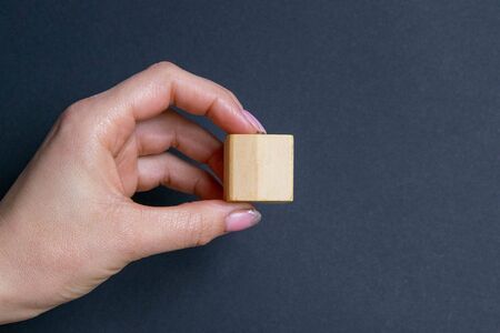 The hand holds 1 cube on a black background, with a seat for text.の写真素材