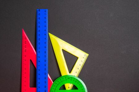 Back to school. Multicolored rulers on a black background. Copy space for text.の写真素材