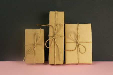 Banner with Wrapped in Eco craft holidays present gift boxes flower on pinc table top view. Flat lay stylingの写真素材