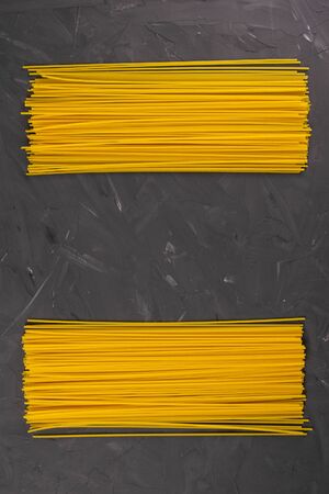 Yellow long spaghetti on a dark background. Top views with clear spaceの写真素材