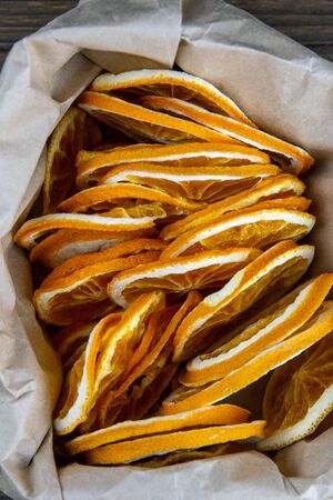 Fruit chips from orange slices in a paper bag. Top views, close-up.の写真素材