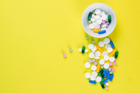 Tablets are scattered on the table, dosage for the patient. Top views with clear spaceの写真素材