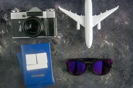 Airplane, glasses, vintage cameras, passport and wooden cubes on which you can write a date on tha dark background. Top views.の写真素材