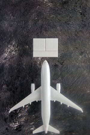 Airplane with wooden cubes on which you can enter your date stands on a dark background. Top views.の写真素材
