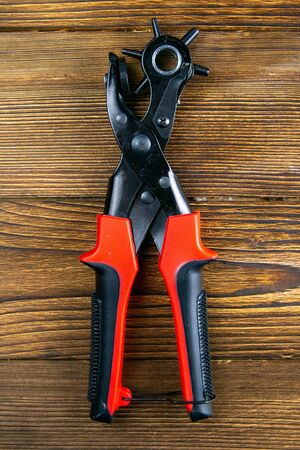 Red hole punch on a wooden table. Top views, close-up.の写真素材