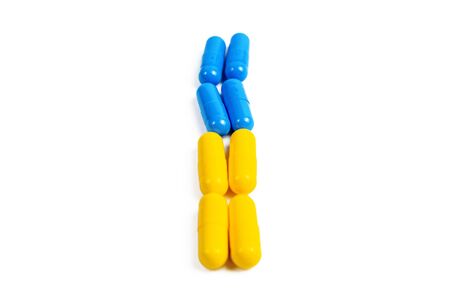 Close up of a pile of blue yellow pills isolated on white background.の写真素材