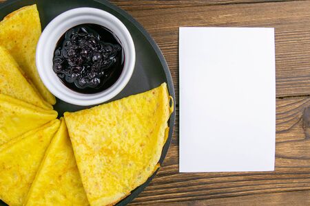 Pancakes with bluberrys in frying pan with notepad on rustic wooden table. Top views with clear space.の写真素材