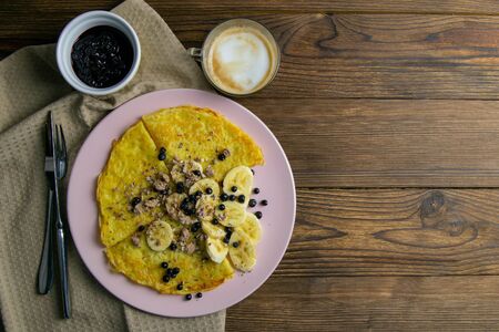 Tasty Pancakes with Bananas, Blueberries and Honey on pink Plate. Top view with clear space on dark wooden table. Homemade Pancakes. Pancakes Breakfast Food.の写真素材