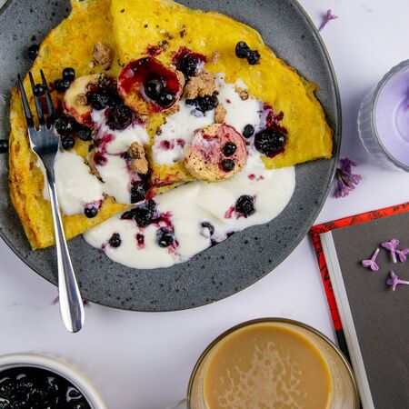 Pancakes with berries and bananas on a grey plate with blank notepad over dark marable background, top view. From above, flat lay, overhead.の写真素材