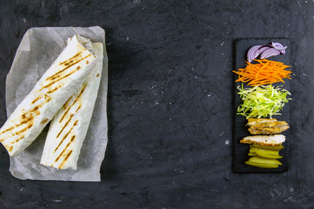Homemade shawarma, burrito, chicken roll with vegetables and sauce. Top view shawarma and...