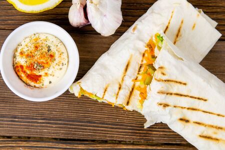 Homemade shawarma, burrito, chicken roll with vegetables and sauce. Top view ingredients.の写真素材