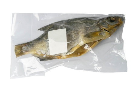 Dried bream in a transparent package with a white label on a white background. Snack Fish to beer....