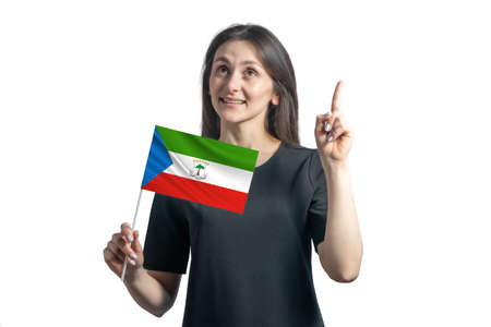 Happy young white woman holding flag of Equatorial Guinea and points thumbs up isolated on a white background.の写真素材
