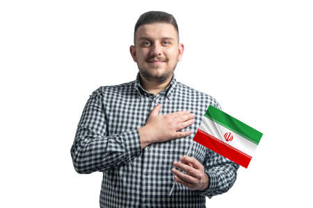 White guy holding a flag of Iran and holds his hand on his heart isolated on a white background With love to Iran.の写真素材
