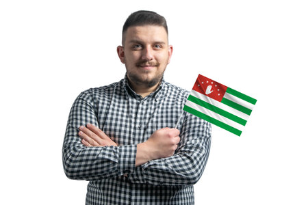 White guy holding a flag of Abkhazia smiling confident with crossed arms isolated on a white background.の写真素材