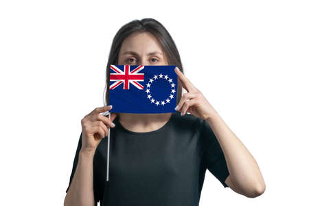 Happy young white woman holding flag Cook Islands flag and covers her face with it isolated on a white background.の写真素材
