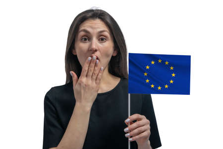 Happy young white woman holding flag of European Union and covers her mouth with her hand isolated on a white background.の写真素材