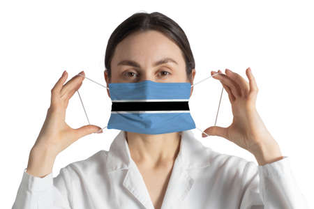 Respirator with flag of Botswana Doctor puts on medical face mask isolated on white background.の写真素材