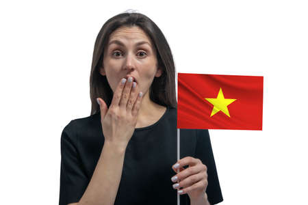 Happy young white woman holding flag of Vietnam and covers her mouth with her hand isolated on a white background.の写真素材