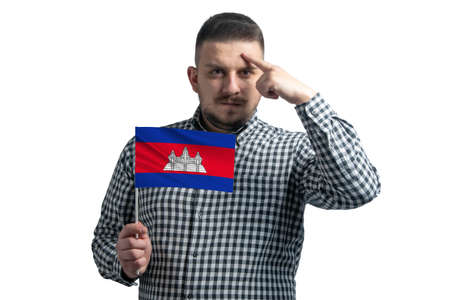 White guy holding a flag of Cambodia and a finger touches the temple on the head isolated on a white background.の写真素材