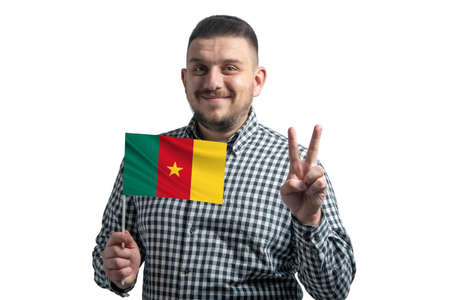 White guy holding a flag of Cameroon and shows two fingers isolated on a white background.の写真素材