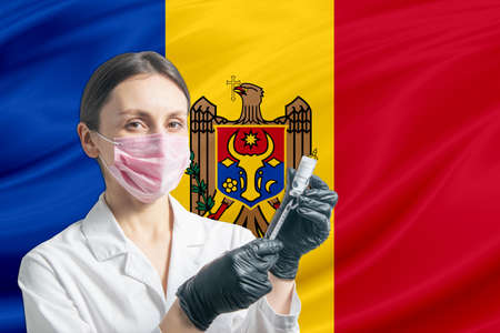 Girl doctor prepares vaccination against the background of the Moldova flag. Vaccination concept Moldova.の写真素材