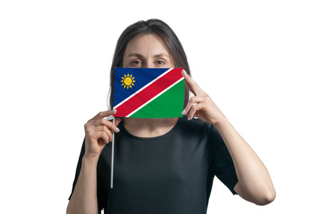 Happy young white woman holding flag Namibia flag and covers her face with it isolated on a white backgroundの写真素材
