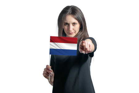 Happy young white woman holding flag of Netherlands and points forward in front of him isolated on a white backgroundの写真素材