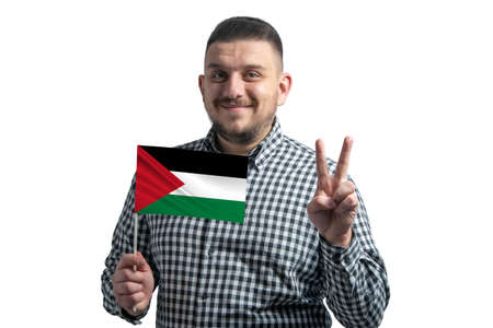 White guy holding a flag of Palestinian state and shows two fingers isolated on a white backgroundの写真素材