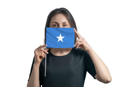 Happy young white woman holding flag Somalia flag and covers her face with it isolated on a white background.の写真素材
