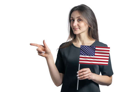 Happy young white woman holding flag United States and points to the left isolated on a white background.の写真素材