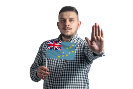 White guy holding a flag of Tuvalu and with a serious face shows a hand stop sign isolated on a white background.の写真素材