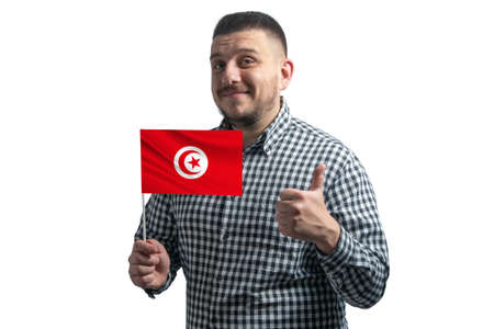 White guy holding a flag of Tunisia and shows the class by hand isolated on a white background. Like for Tunisia.の写真素材