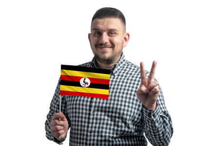 White guy holding a flag of Uganda and shows two fingers isolated on a white background.の写真素材